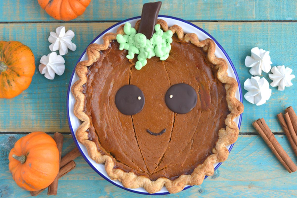 ricetta pumpkin pie decorata a zucca per halloween torta di zucca meringhe cannella occhi di cioccolato ciuffetto verde di crema