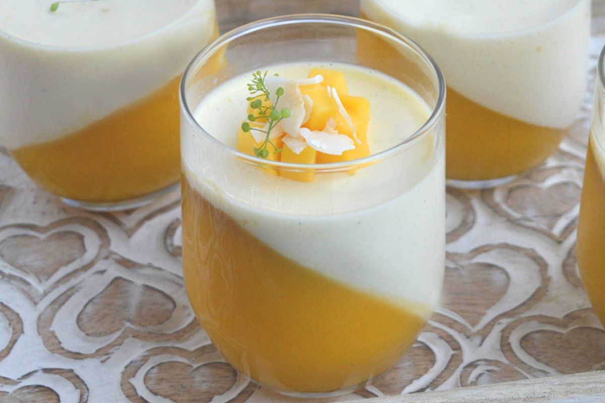 ricetta-panna-cotta-con-gelee-di-mango-inclinata-obliqua-decorata con pezzetti di mango e scaglie di cocco