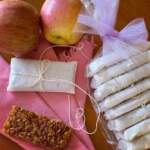 nell'angolo in basso a sinistra barretta muesli come da ricetta. Intorno set di barrette avvolte ciascuna in carta da forno e legate con spago come piccoli pacchettini regalo