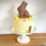 torta gialla coniglietto di pasqua fiori bianchi pesca rosa verdi